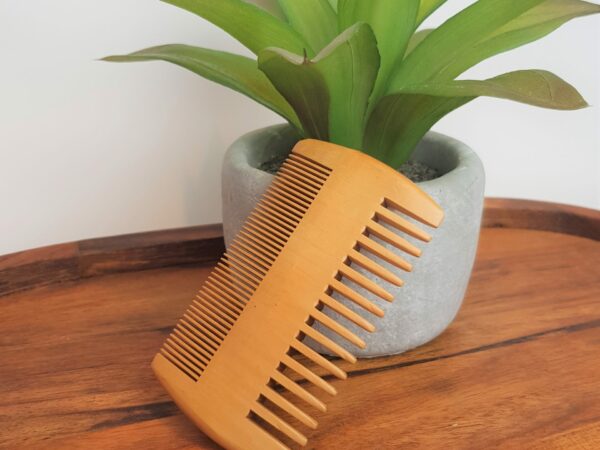 beard comb against plant on wood