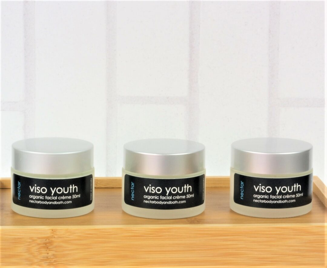 Viso Youth moisturisers in glass pots with silver lids on wood base