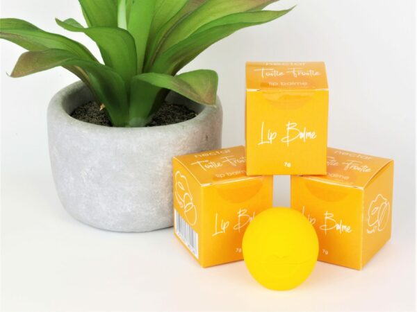 lip balm tootie footies smooth ball with plant and boxes
