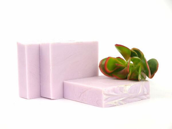 three purple soaps with plant
